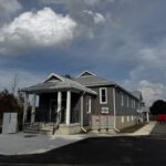 Front view of completed community hall with portico and multiple sections