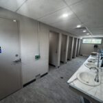 Public washroom interior with multiple sink stations and stalls