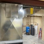 Basement water heating system with pressure tank and wall-mounted boiler installation