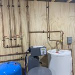 Radiant heating manifold with copper tubing, thermostats, and dual storage tanks