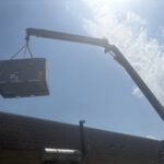 Rooftop HVAC unit being craned into place