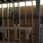 Organized commercial pipe rough-in on framed wall with ladder