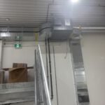 Warehouse interior with metal framing and overhead ductwork
