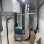 Mechanical utility room with wall-mounted plumbing and HVAC equipment