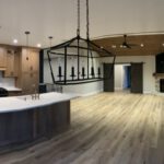 Modern kitchen with barn door, dark island, pendant lighting, and water views