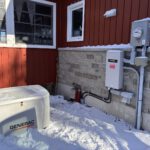 Generac standby generator installed beside snowy house