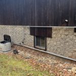 Generac standby generator installed against wood siding
