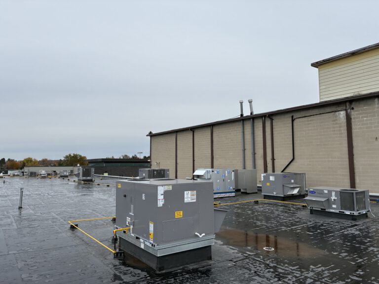 Rooftop commercial HVAC units installed on brick building