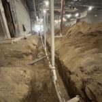 Underground basement piping installation at night