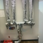HVAC ductwork with insulation and control dampers in ceiling cavity