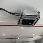 Electrical control unit mounted on finished mechanical room wall with piping