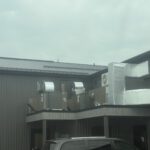 Exterior HVAC and mechanical equipment installed on elevated platform with metal framework