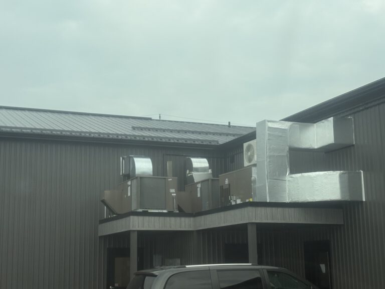 Exterior HVAC and mechanical equipment installed on elevated platform with metal framework