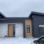 Modern home exterior with charcoal siding and natural wood accents