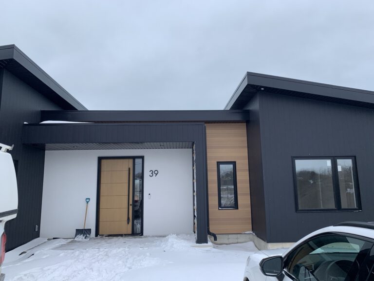 Modern home exterior with charcoal siding and natural wood accents