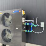Outdoor heat pump unit with manifold piping and color-coded fittings