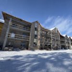 Apartment building exterior in winter with stone and brick facade
