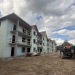 Multi-story building facade under construction with protective wrap