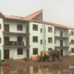 Wide construction site with apartment building and equipment