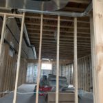 Interior frame with metal ductwork and insulation installation visible