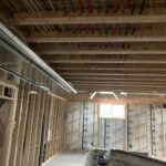 Framing cavity showing organized blue and red hydronic heating lines