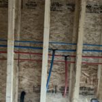 Wall cavity with embedded color-coded heating pipes in insulation