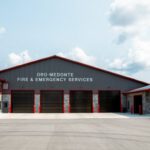 Panoramic exterior view of fire hall with landscape and clear sky