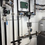 Close-up of radiant system manifold with blue and black piping and control actuators