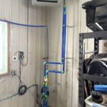 Overhead view of radiant floor heating tubing installation in open beam space