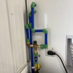 Detail of blue and green PEX tubing connections with smart control valve