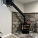 Finished wood stove in stone corner nook