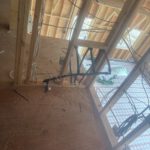 Ceiling view of wooden joists with black radiant heating lines installed