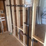 Under-floor view of joists with suspended radiant heating tubing