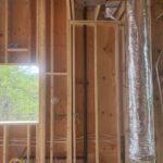 Window opening framed with radiant heating and electrical rough-in visible