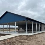 Finished pavilion with open sides, blue roof, white posts, brick siding