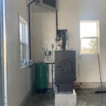 Outdoor wood boiler furnace installed indoors with expansion tank
