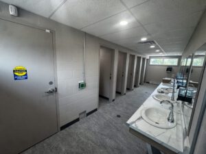 Public washroom interior with multiple sink stations and stalls