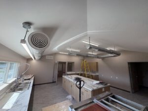 Kitchen dining area with suspended ductwork and exhaust system installation