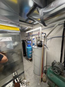 Mechanical room showing installed hot water tank and plumbing connections