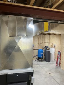 Basement water heating system with pressure tank and wall-mounted boiler installation