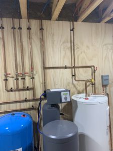 Radiant heating manifold with copper tubing, thermostats, and dual storage tanks