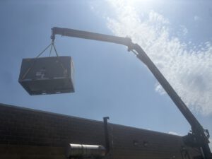 Rooftop HVAC unit being craned into place