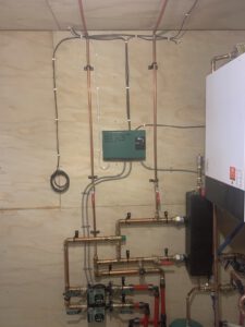 Ceiling-mounted in-floor heating distribution manifold with copper tubes