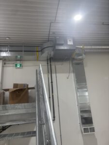 Warehouse interior with metal framing and overhead ductwork