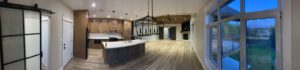 Modern kitchen with barn door, dark island, pendant lighting, and water views