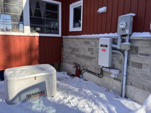 Outdoor Generac generator installation with meter and gas connections in snow