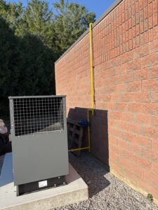 Overhead view of generator installation with metal frame and piping connections
