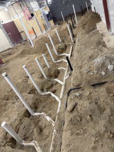 Installed PVC and drain piping on concrete foundation wall