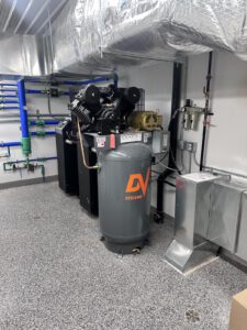 Air compressor with manifold piping and pressure gauge installation detail