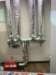 HVAC ductwork with insulation and control dampers in ceiling cavity